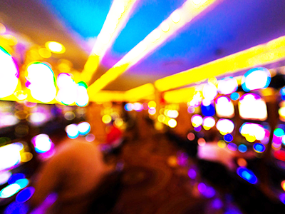 blurred image of people gambling on a slots machine